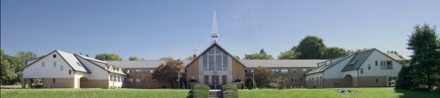 Large church building with steeple and wings